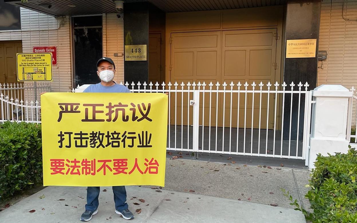2021年9月15日，从大陆来到美国的Zayn在洛杉矶中领馆前手举“要法制不要人治”的标语，抗议中共严打教育培训行业。（Zayn提供）