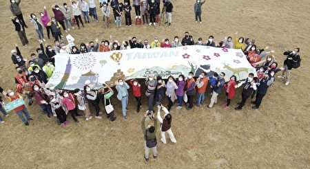 由云林毛巾业者代表百人百手高举【台湾景观巨幅毛巾壁画】在广阔的耕地上透过空中俯瞰，尤为壮丽。