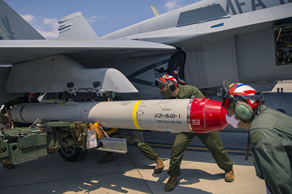 2020年4月28日，在日本岩國基地，美軍士兵正在將AGM-84D魚叉導彈裝載到F/A-18大黃蜂戰機上。（美國海軍陸戰隊）