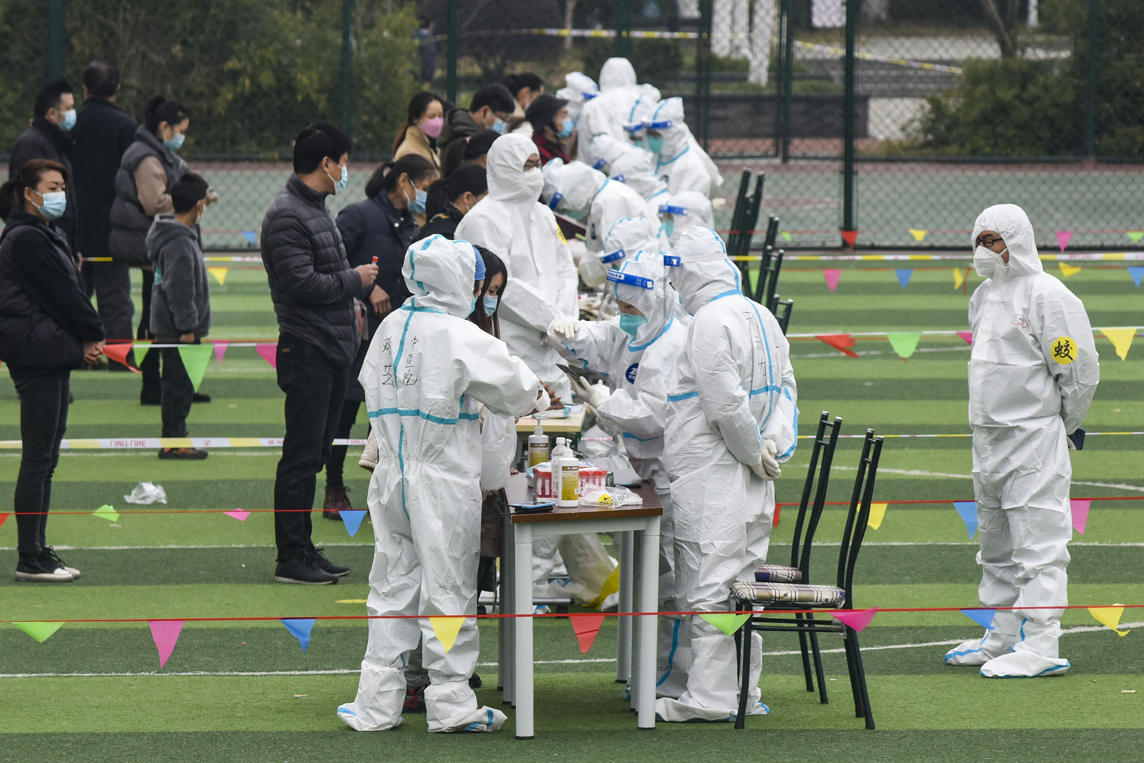 长江三角地区停工停产,封城或持续到明年3月?幼儿刚学走路,已做了70次核酸检测?坚持疫情“动态清零”,中国经济实质受损,谁来买单?图为2021年12月8日,浙江省宁波市的居民接受Covid-19冠状病毒核酸检测。(China OUT/AFP)