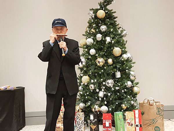图：温哥华台光教会于2021年12月19日举办圣诞餐会，图为精彩的口琴表演。（邱晨/大纪元）