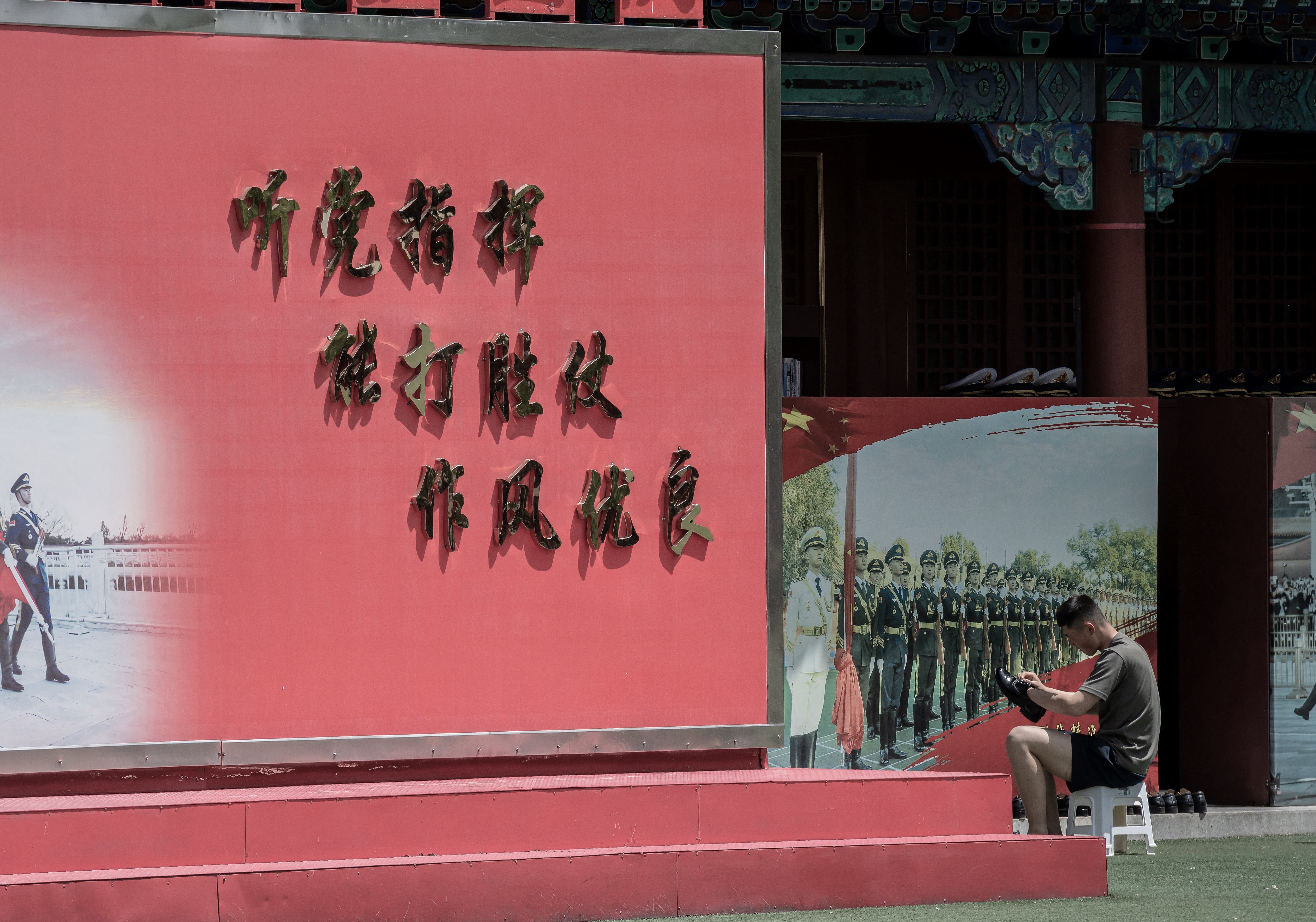 近年,中國大陸民眾拒服兵役的事件頻現官媒報導,即便嚴厲懲處,也難阻嚇。圖為2020年5月18日,一名士兵在北京故宮入口旁擦鞋。(Nicolas Asfouri / AFP)