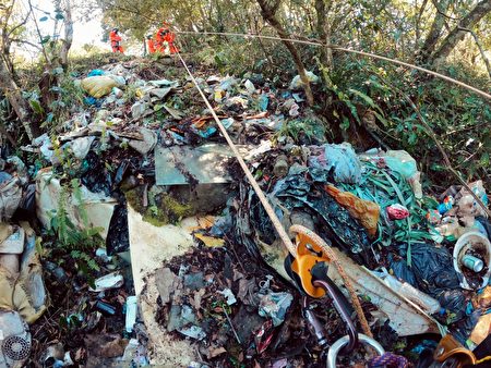 南投县仁爱乡台14线87K至87.5K路段有多处“垃圾瀑布”，志工以绳索吊挂垂降至山谷，沿着坡地收集垃圾。