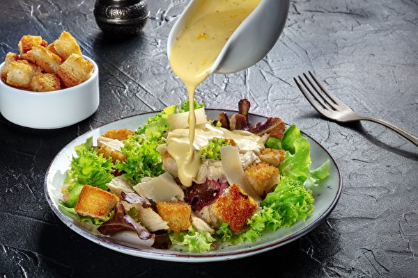 Chicken,Caesar,Salad,With,The,Classic,Dressing,Being,Poured,,Croutons,