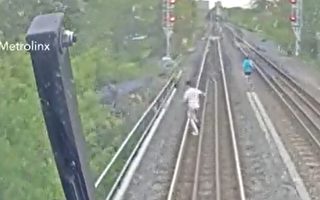 在铁轨上行走 三名年轻人险被火车撞到