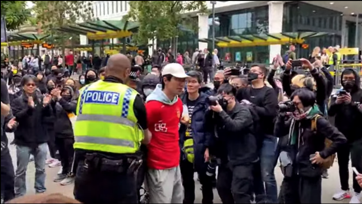 At the rally after the parade, a suspected pro-Communist man in red came to the scene to make trouble. He was taken away by two police officers, amid the loud applause of all the people there. (Jack, Tian Yu/The Epoch Times)