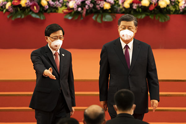 2022年7月1日，香港新任行政长官李家超（左）请习近平（右）到台下就坐。习近平在香港没法在主席台就坐。（Justin Chin/Bloomberg via Getty Images）