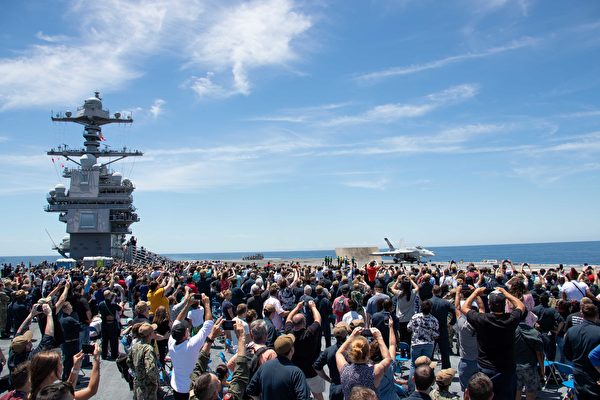 2022年6月25 日，美军福特号航母（CVN 78）的水手及家人和朋友在甲板上观赏第10,001 次舰载机弹射升空。（美国海军）