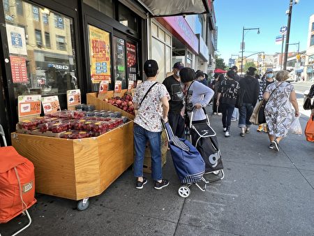 根據規定，商家人行道攤位不能超過4呎。圖為法拉盛地鐵口超市水果攤，在接受宣導後，減少延伸出人行道的範圍。