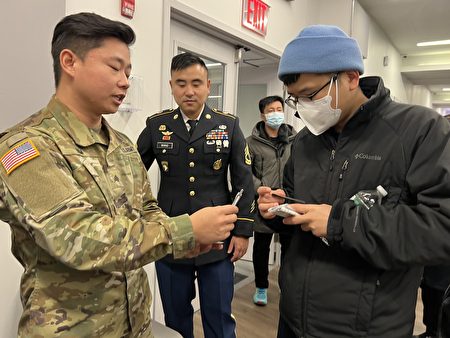 2022年11月19日，华人在活动上了解加入陆军条件和福利，Fan Wang（左二）介绍，加入美国陆军后，他免费完成了大学学业。