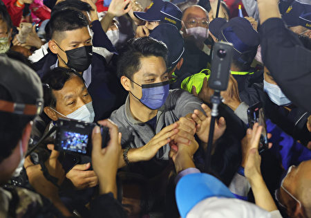 台北市长选举结果大势已定，国民党候选人蒋万安（中）26日晚间自行宣布当选，进场时受到支持群众簇拥，他也亲切向支持者致意。