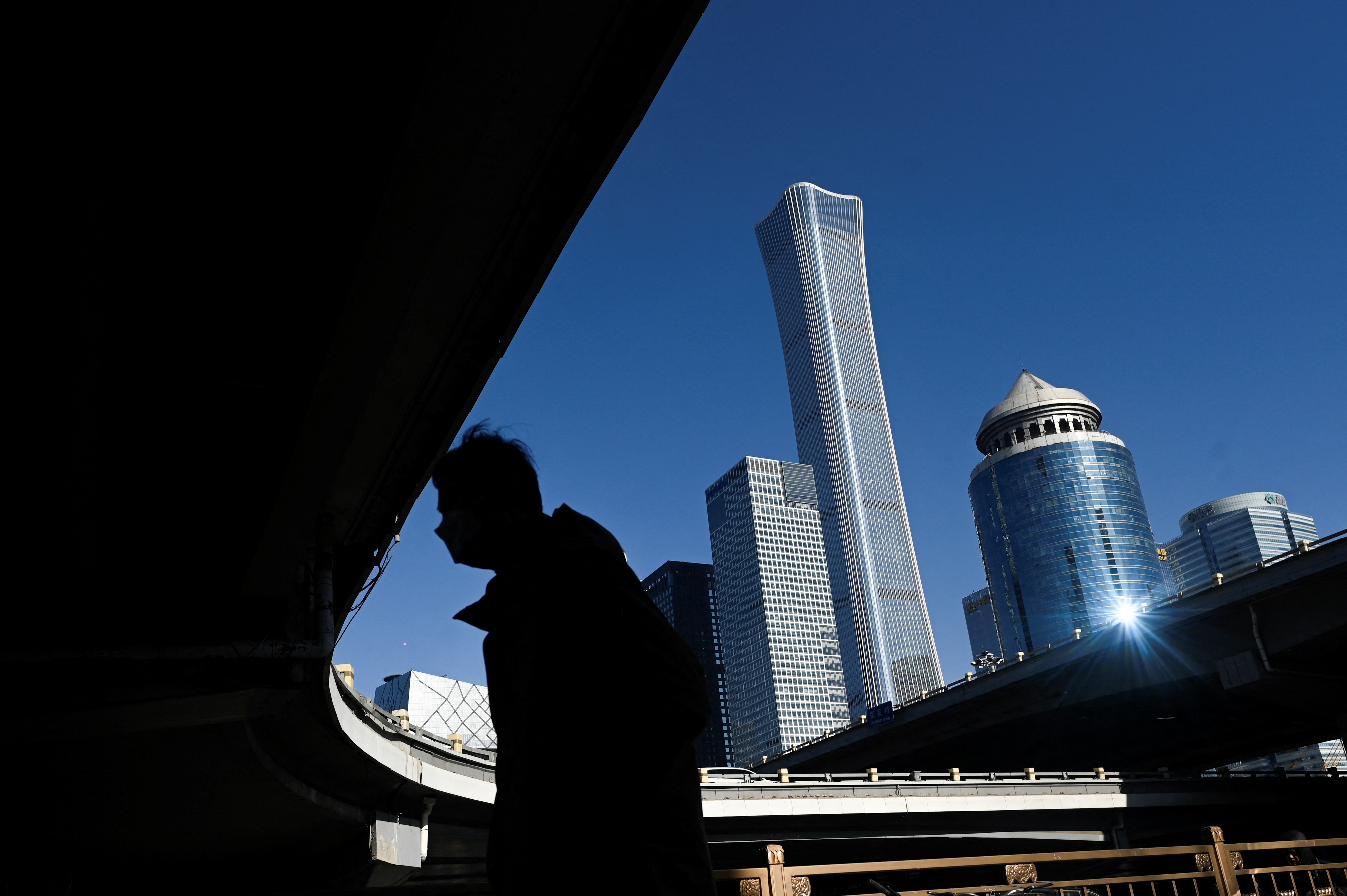 圖為2023年1月16日,行人在北京中央商務區行走。(Wang Zhao/AFP)