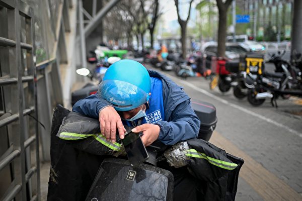 2023年4月1日，北京一位外賣員在電動車上休息。（WANG ZHAO/AFP via Getty Images）