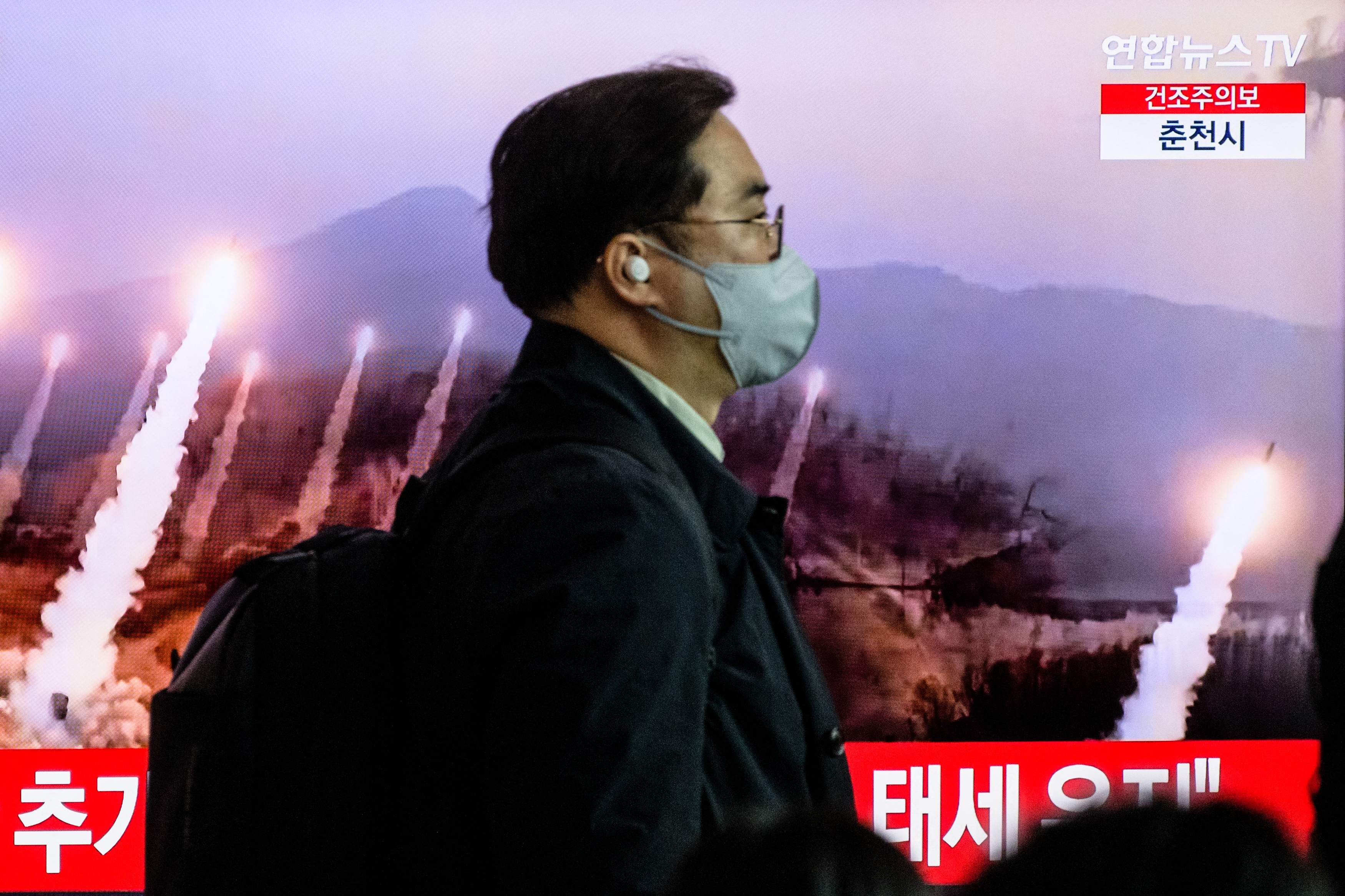 朝鲜不但支持俄罗斯入侵乌克兰,过去一年,朝鲜史无前例地发射了70多枚导弹。图为2023年3月27日,一名男子走过播放朝鲜导弹试验的档案镜头。(Anthony Wallace/AFP)