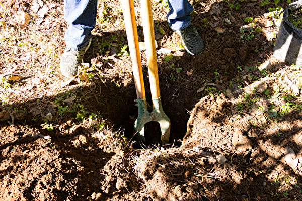A Man Using A Hole Digger To Make Hole To