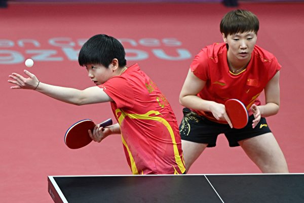 2023年9月30日，杭州亚运会上，中国女双队员孙颖莎（左）、王曼昱（右）在比赛中。（JUNG YEON-JE/AFP via Getty Images）