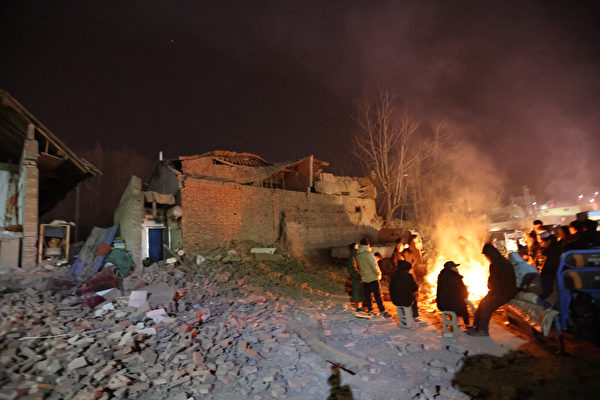 2023年12月19日，甘肃6.2级地震发生后，当地民众在空旷场地烤火避难。（ STR/AFP via Getty Images）