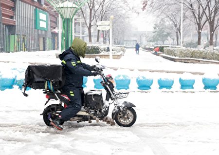 2024年2月4日，湖北武汉大雪，外卖员在雪地里艰难行驶。（VCG/VCG via Getty Images △）