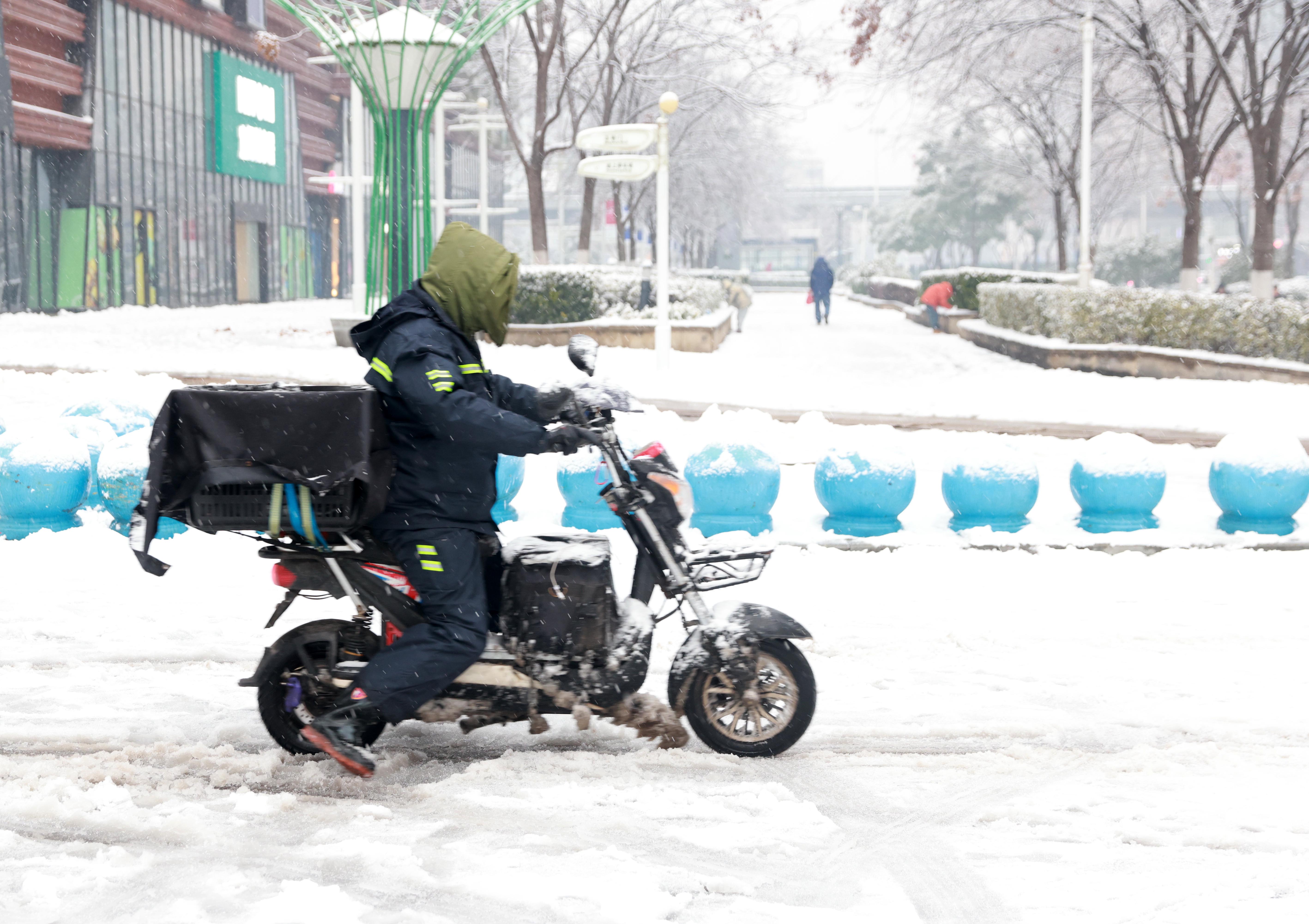 2024年2月4日，湖北武漢大雪，外賣員在雪地裡艱難行駛。（VCG/VCG via Getty Images △）
