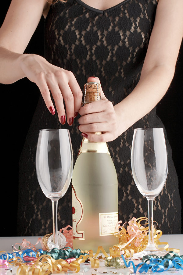 Woman In Sexy Black Evening Dress Opening Bottle Of Champagne