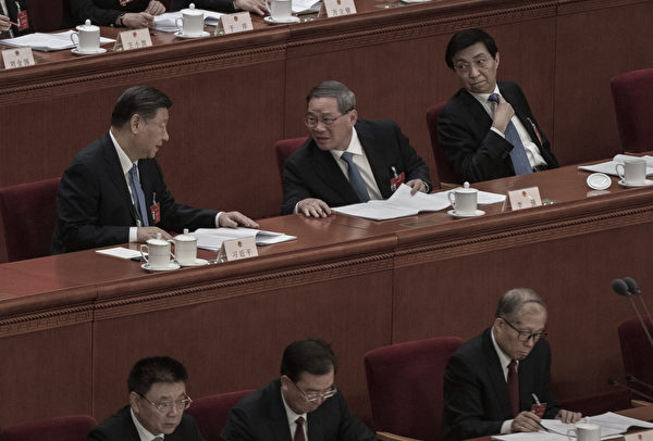 2024年3月8日，中共两会第二次全体会议，两高作报告时，中共党魁与总理李强攀谈。（Kevin Frayer/Getty Images)