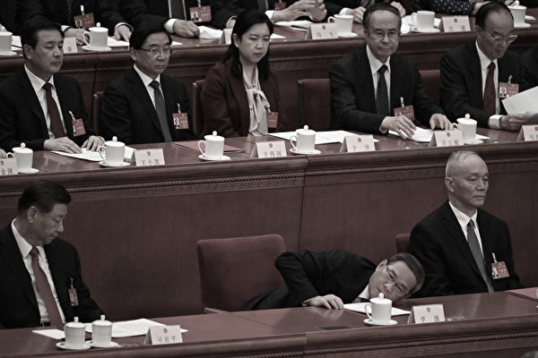 2024年3月11日，中共全国人大会议闭幕式上，李强弯腰，要到桌下捡东西。（Jade Gao / AFP via Getty Images）