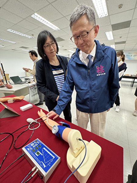 元智大学医护学院筹备处陈芸主任向副市长王明钜示范教学测量血压。