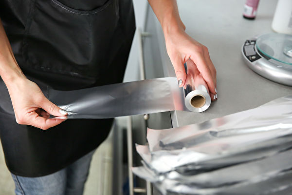 Woman S Hand Unwinds A Piece Of Aluminum Foil From A