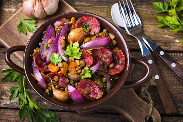 Lentil With Sausage And Vegetables In Pot On Rustic Background