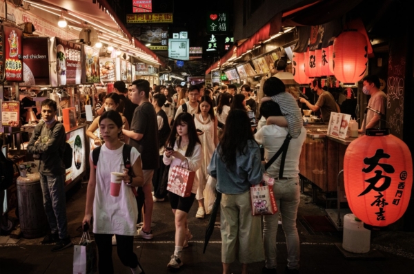 2024年5月26日，东说念主们走过台北街说念上的好意思食摊贩。（Yasuyoshi Chiba / AFP via Getty Images）