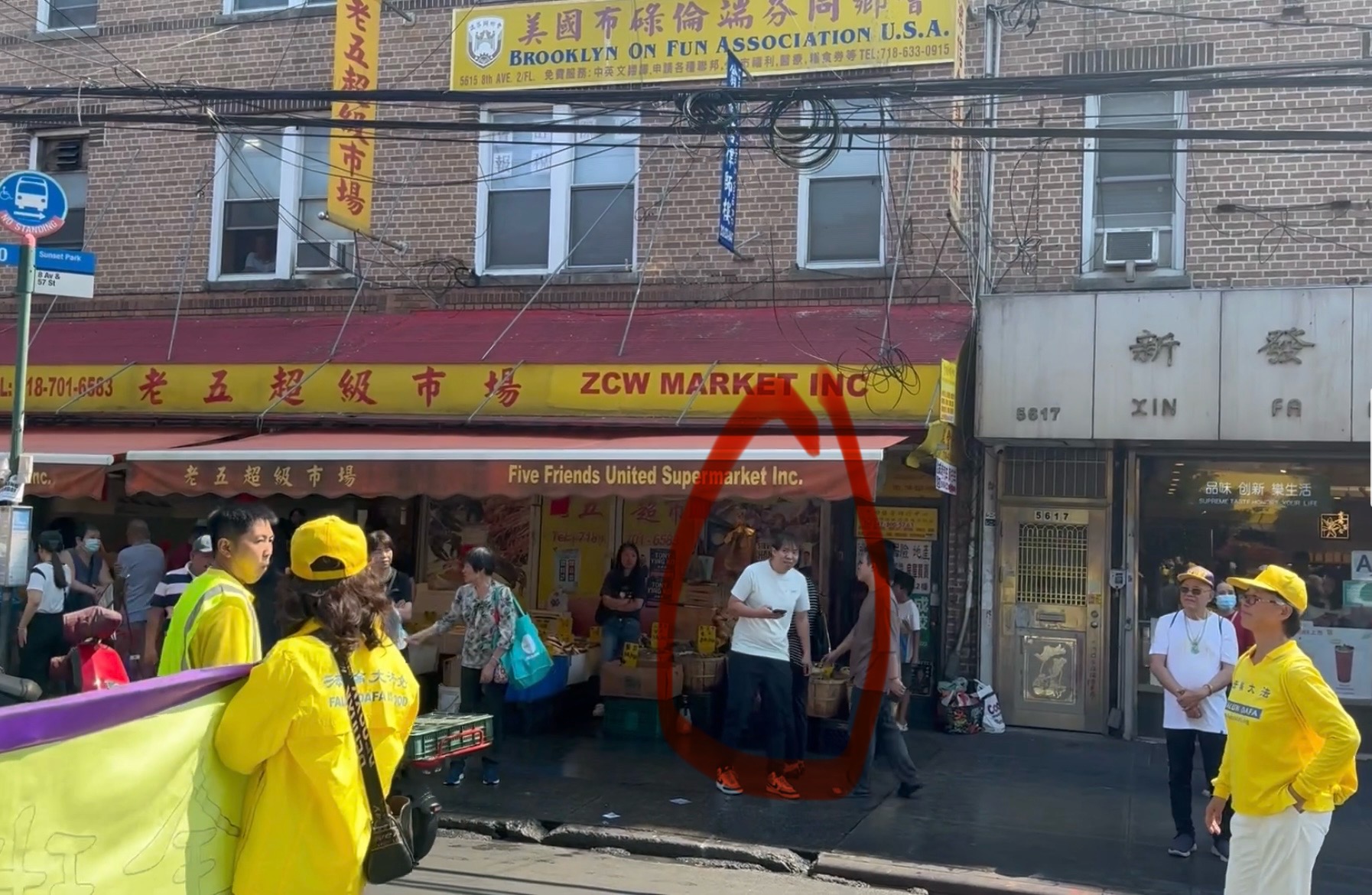 红色圆圈中的男子2024年9月14日在法轮功学员于纽约布鲁克林的游行中，对法轮功学员王立荣（右一）进行攻击。（全球退党服务中心）