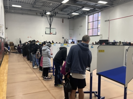 法拉盛提前投票站,填寫選票的桌子前站滿了投票的人。