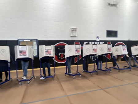 法拉盛提前投票站,填寫投票的桌子前站滿了投票的人。