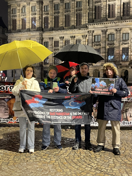 2025年11月23日晚,約10名異議人士來到荷蘭阿姆斯特丹水壩廣場,紀念烏魯木齊大火三周年。圖為韋智堅發言。(反共之聲創辦人劉飛龍提供)