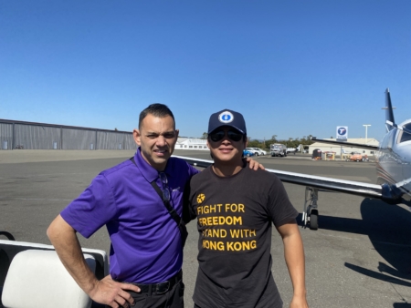 Sky 在機場與客戶合影,準備執飛前往北加州。圖左側為機庫,部分飛行愛好者居住在小型機場周邊,並將私人飛機停放於機庫內。