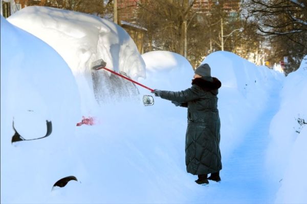 2026年1月26日,一場暴雪襲擊多倫多後,一名女子正試圖清掃貨車上的積雪。 (Frank Gunn/加通社)