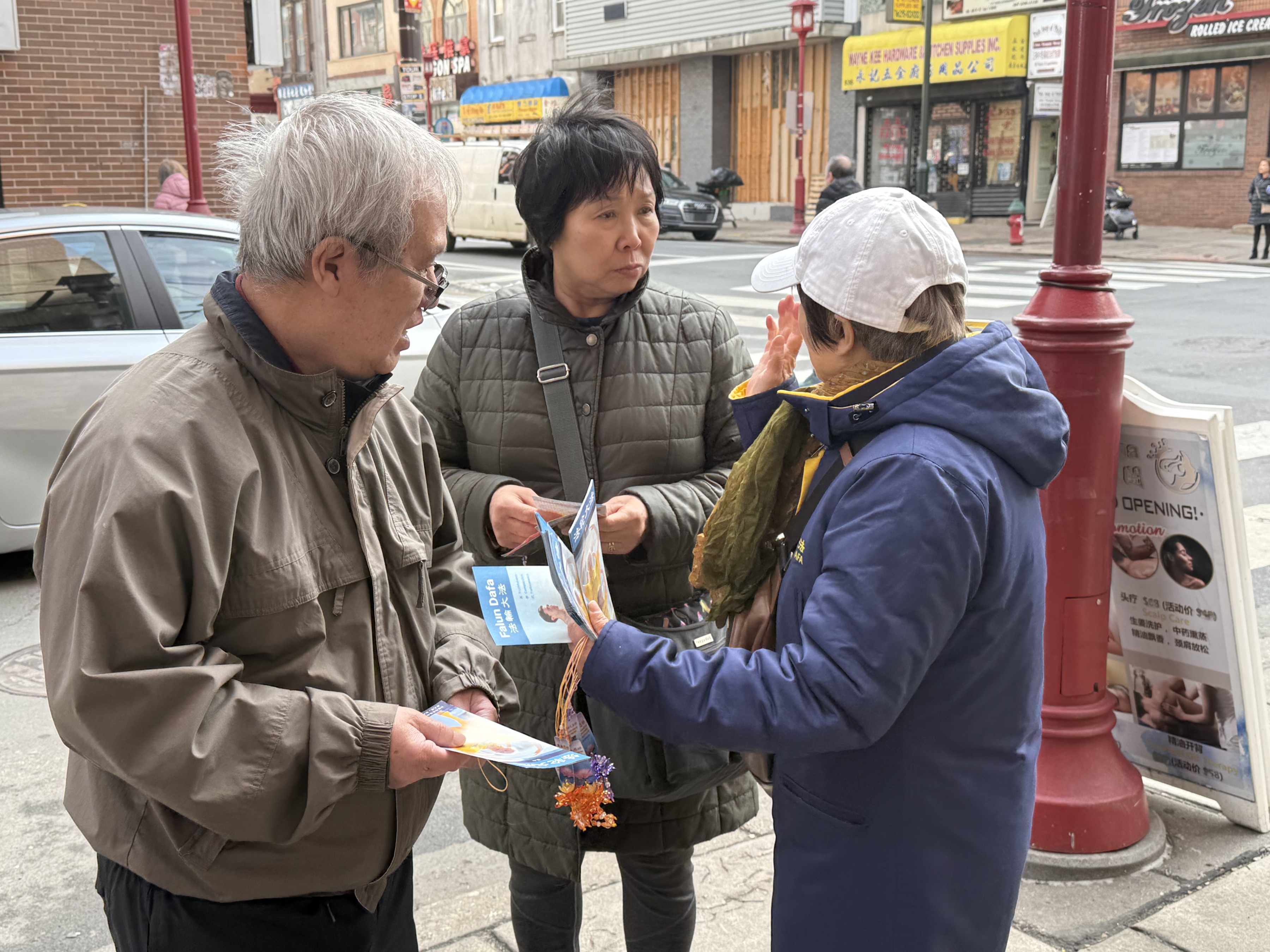2026年2月21日,大費城法輪功學員在費城中國城向民眾發放新年祝福紅包和法輪功真相資料。(李凱西/大紀元)