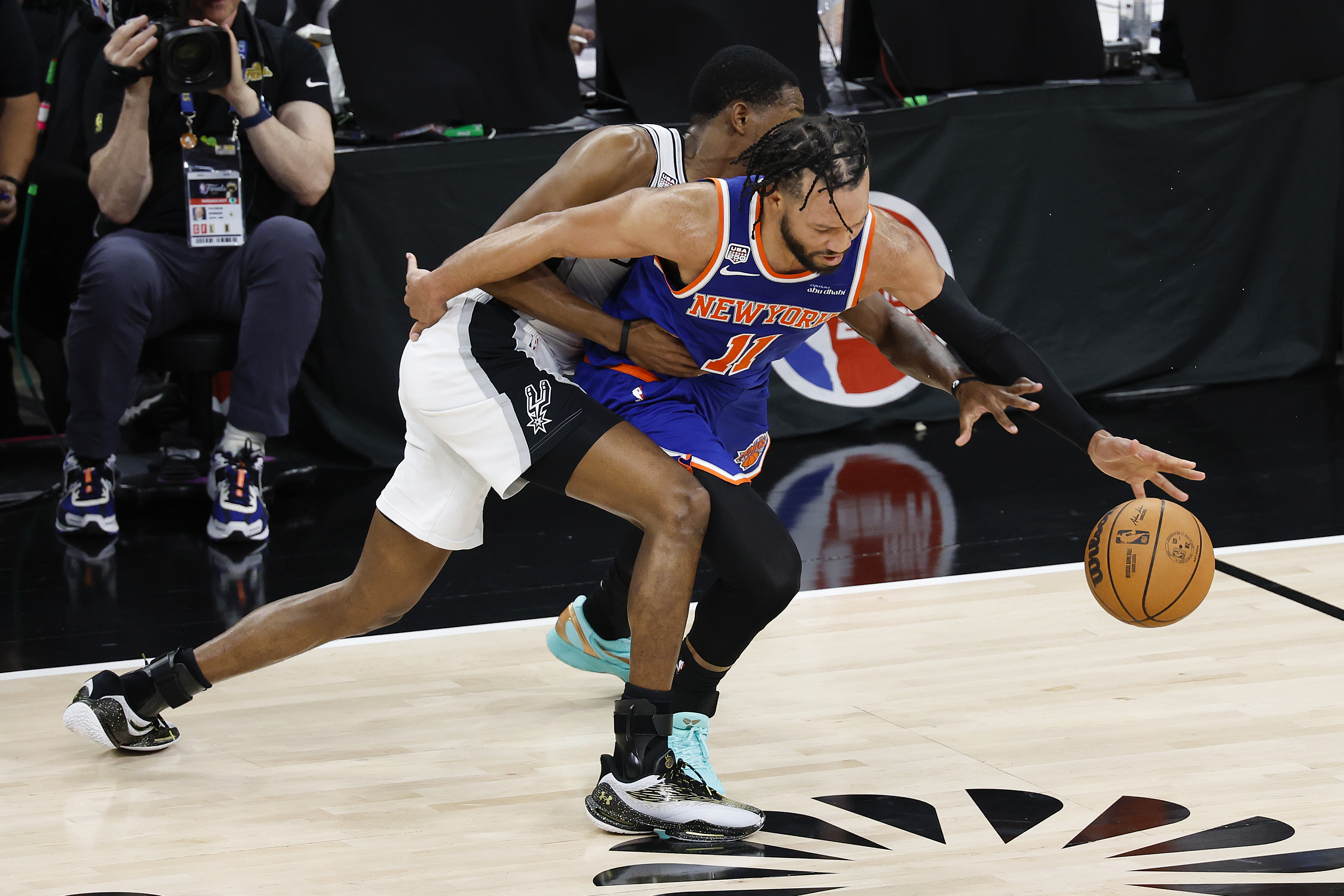 2026年6月13日,NBA總決賽第五場較量,東部冠軍紐約尼克斯隊在客場以94:90擊敗西部冠軍聖安東尼奧馬刺,從而以4:1的總比分,時隔53年後再次奪得總冠軍。圖為雙方球員在比賽中拼搶瞬間。(Ronald Cortes/Getty Images)