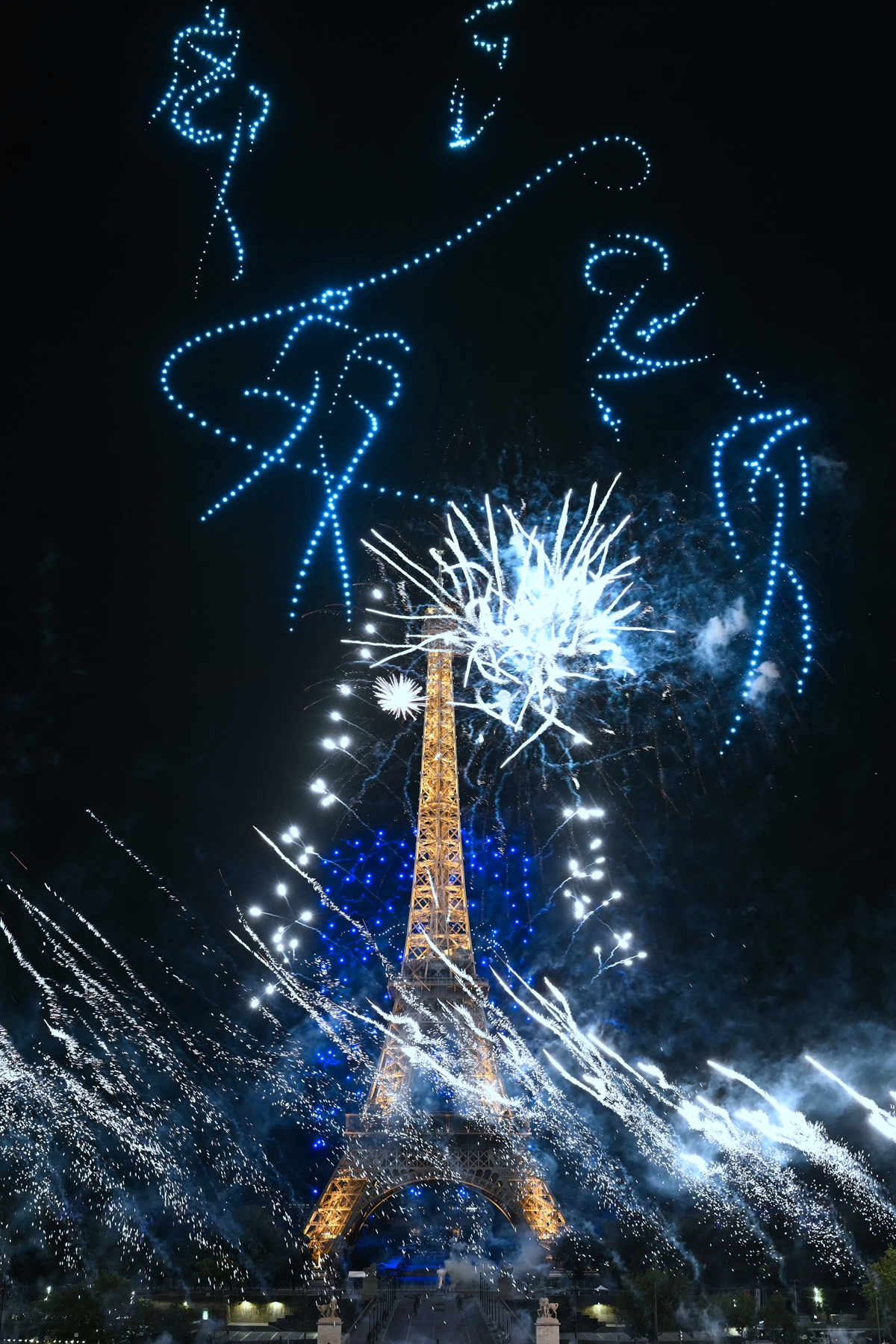 2026年7月13日晚間,盛大的煙火秀和無人機表演在埃菲爾鐵塔前的戰神廣場精彩上演。(Lou Benoist/AFP via Getty Images)