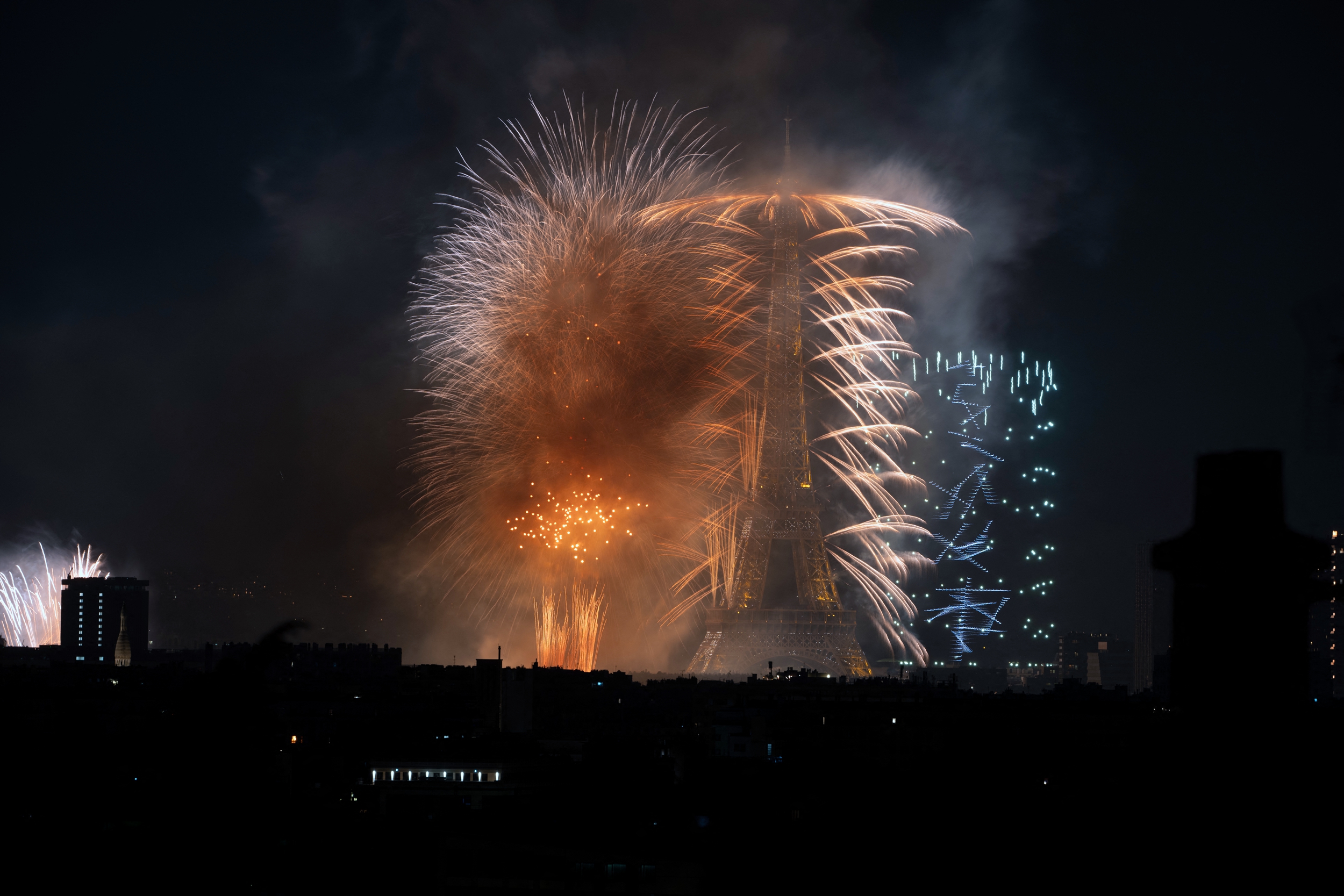 2026年7月13日晚間,盛大的煙火秀和無人機表演在埃菲爾鐵塔前的戰神廣場精彩上演。(Martin Bureau/AFP via Getty Images)