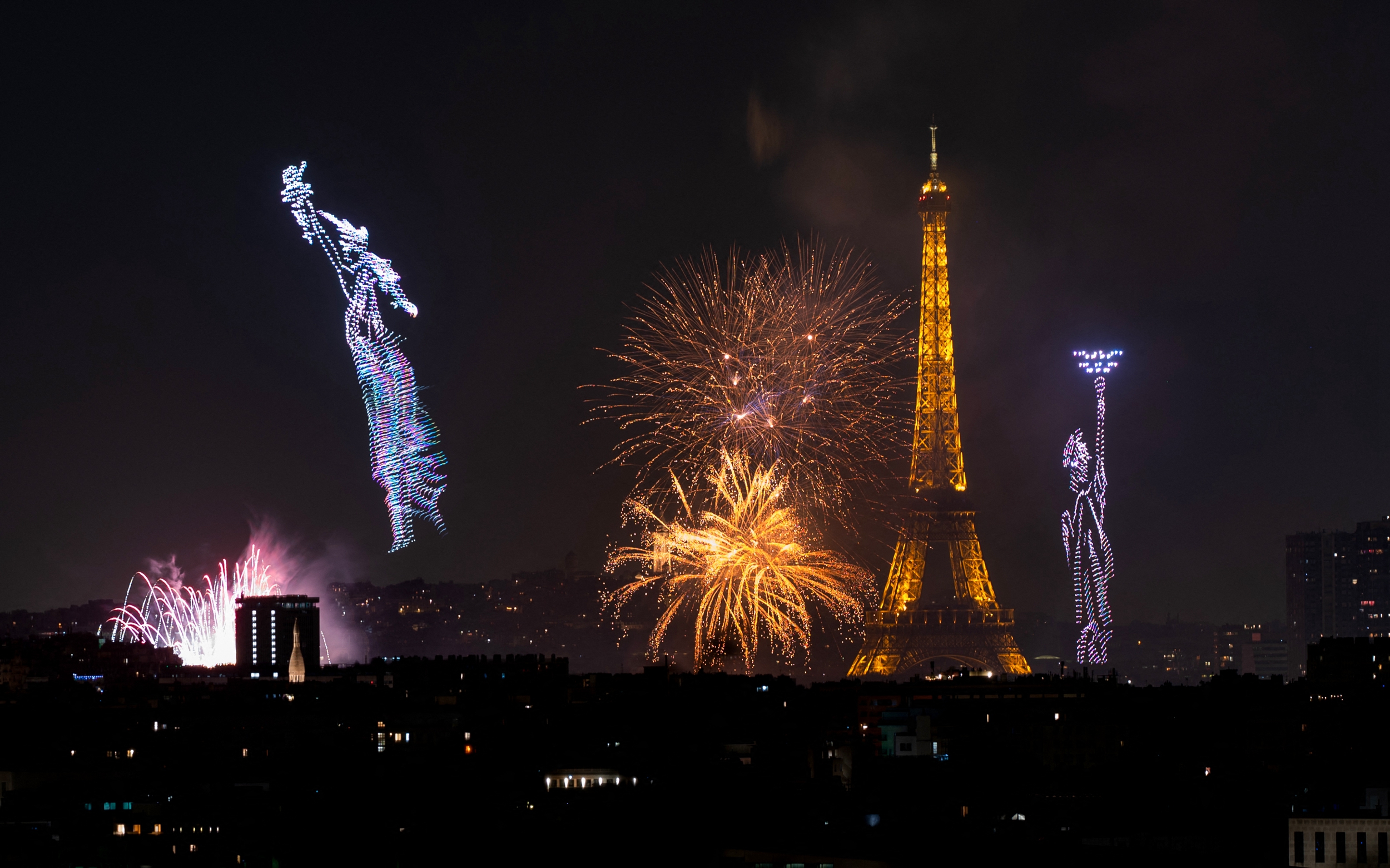 2026年7月13日晚間,盛大的煙火秀和無人機表演在埃菲爾鐵塔前的戰神廣場精彩上演。(Martin Bureau/AFP via Getty Images)