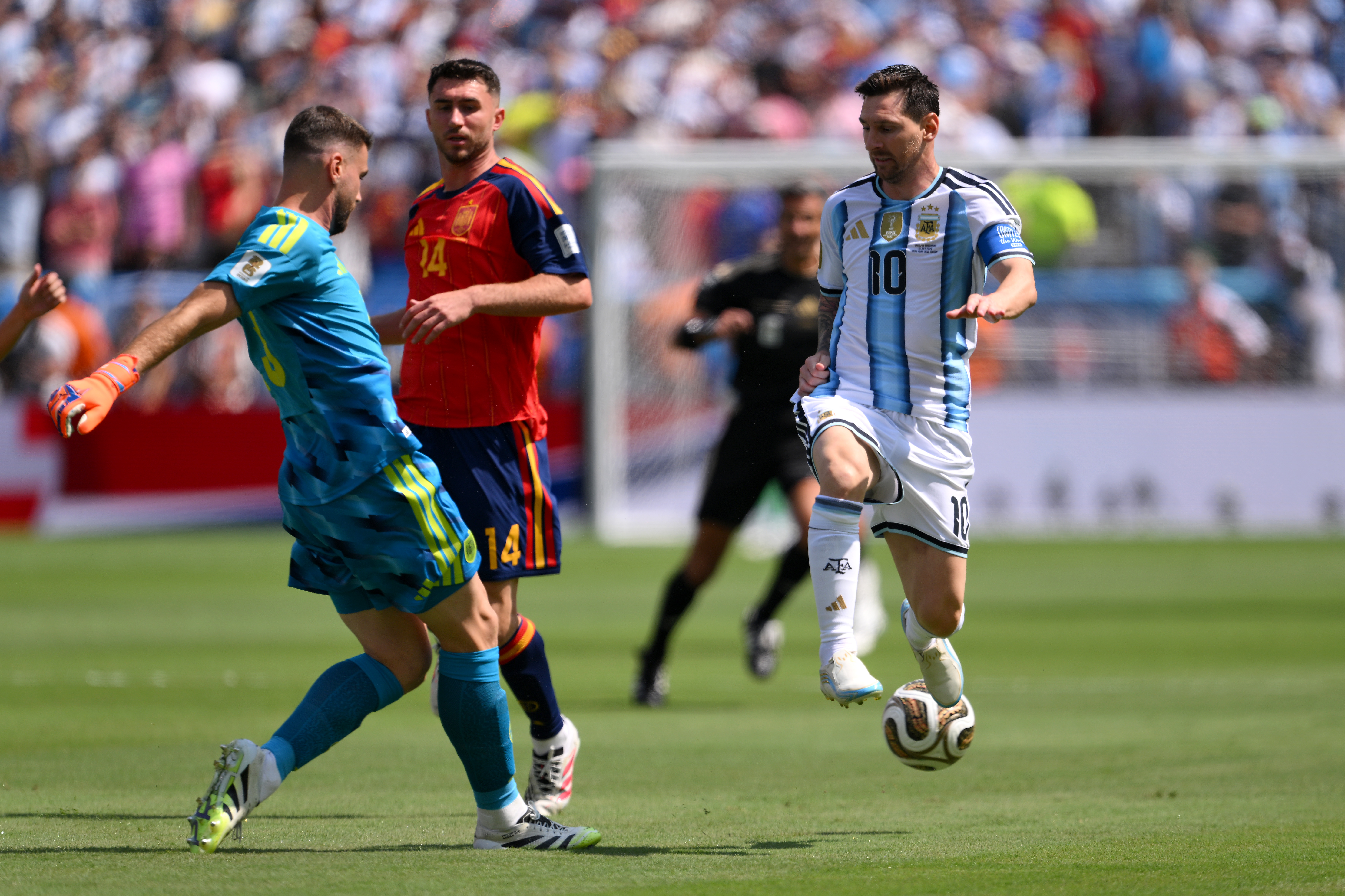 阿根廷隊長梅西(Lionel Messi)反擊中與西班牙門將烏奈・西蒙(Unai Simón)爭搶皮球,險些為球隊首開紀錄。(David Ramos/Getty Images)