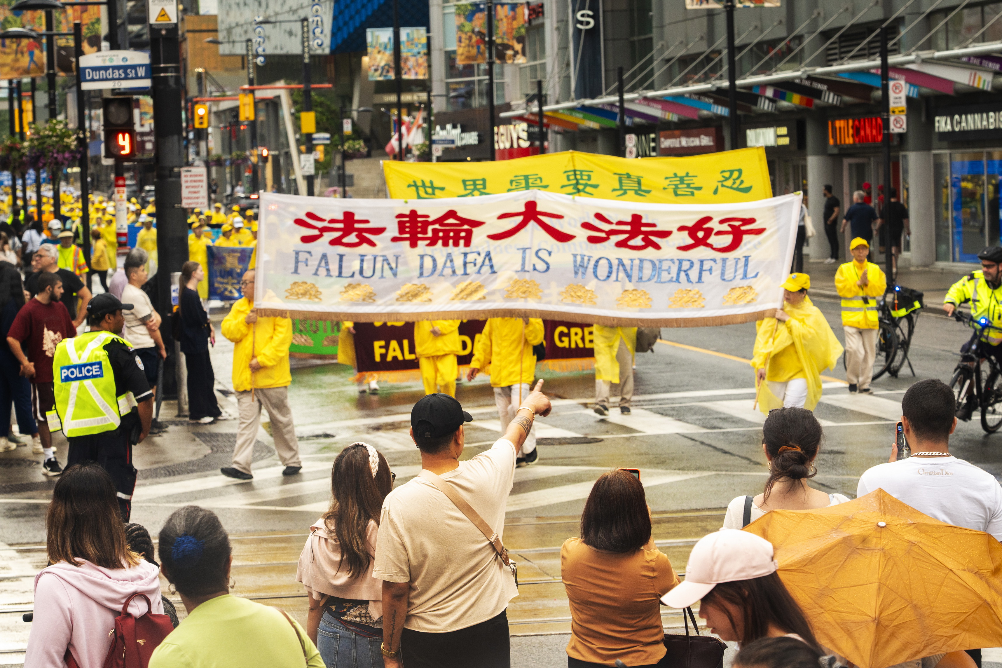 2026年7月18日，多伦多逾千名法轮功学员及支持者在市中心举行大游行，呼吁国际社会关注中共对法轮功长达27年的迫害。路人纷纷驻足观看。（艾文/大纪元）