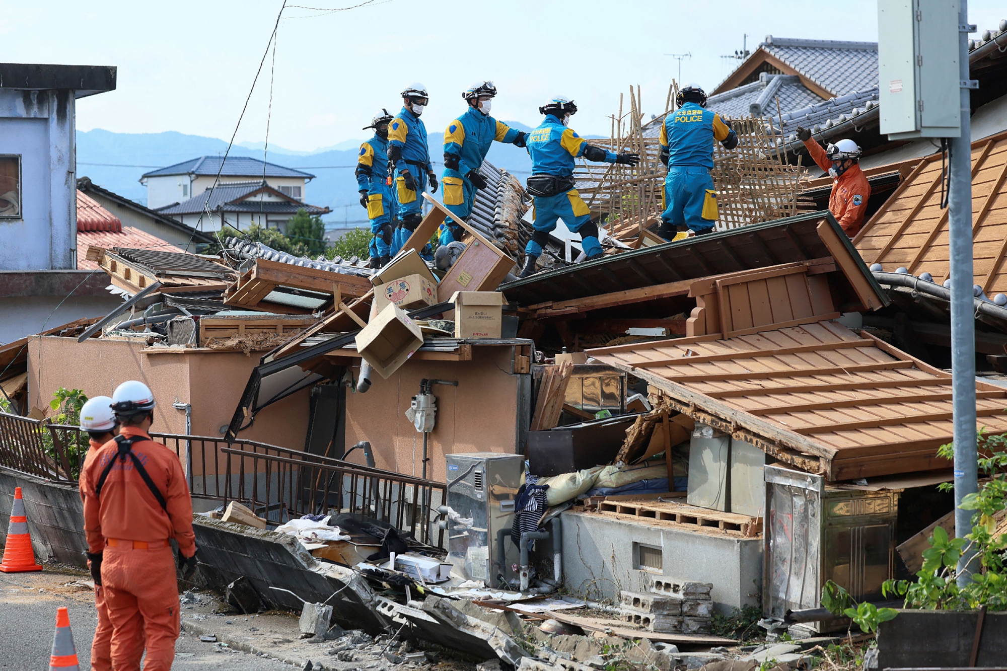 2026年7月30日,日本熊本縣八代市一棟房屋在地震中受損,救援人員在現場開展救援工作。(Jiji Press/AFP via Getty Images)