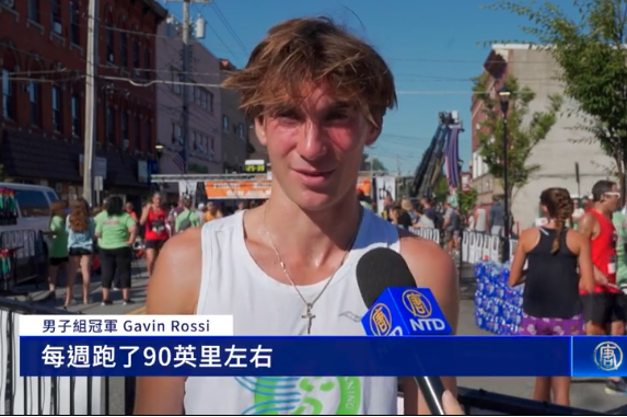 男子組冠軍Gavin Rossi接受採訪。8月16日上午,紐約上州橙縣的中城市,舉行了第20屆的「為社區而跑」活動。(新唐人視頻截圖)