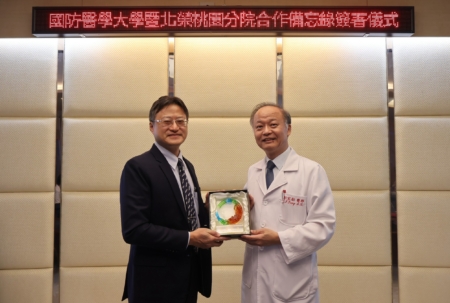 北榮桃園分院彭家勛院長(右)致贈「軍榮情誼 永誌紀念」紀念琉璃獎座予國防醫學大學林致源校長(左),象徵雙方珍視彼此情誼及攜手合作的共同願景。