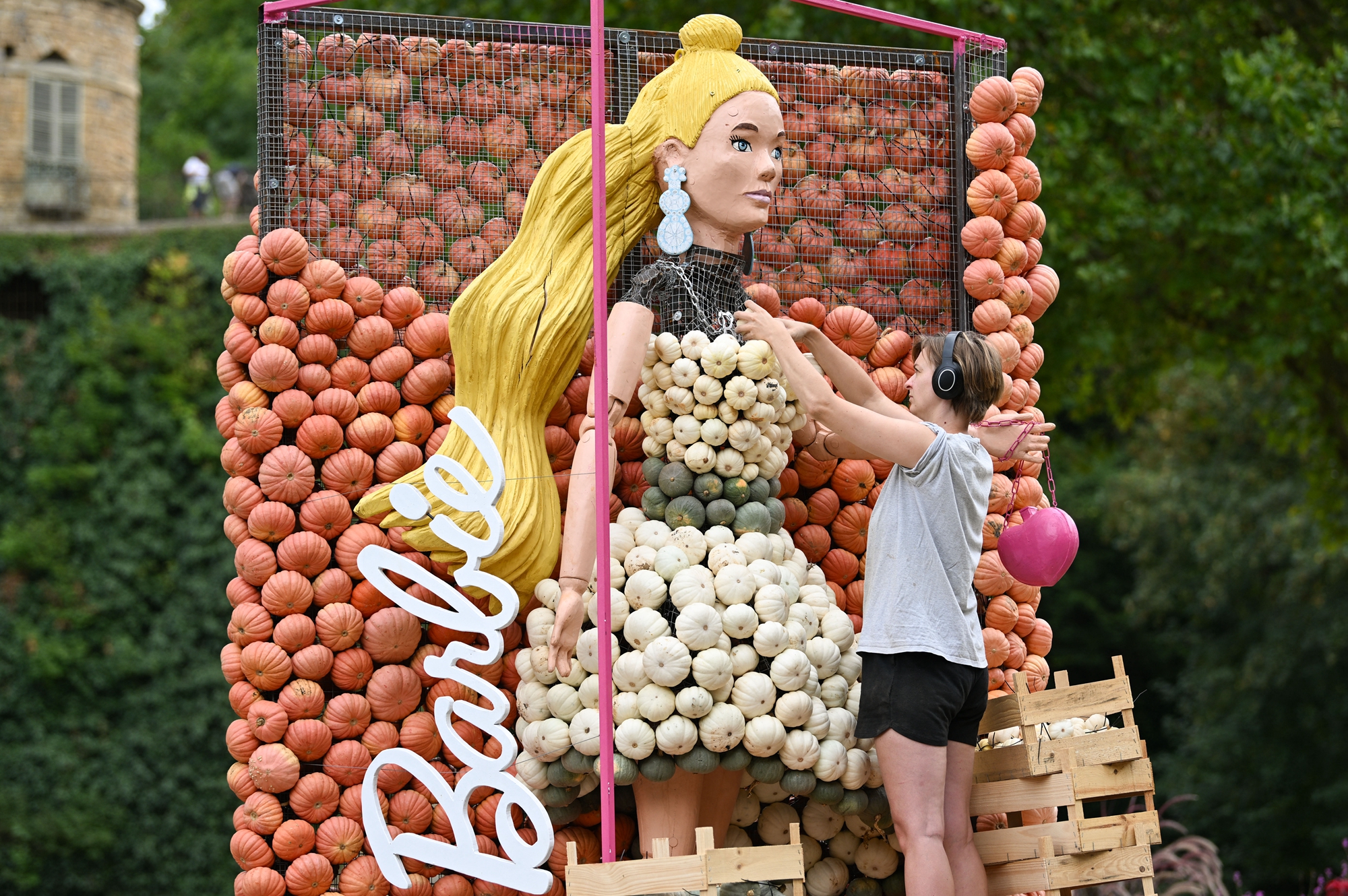 2026年8月20日,德國路德維希堡巴洛克花園(Blühendes Barock),一位藝術家正在完善以芭比娃娃為主題的南瓜雕塑。(Thomas Kienzle/AFP via Getty Images)