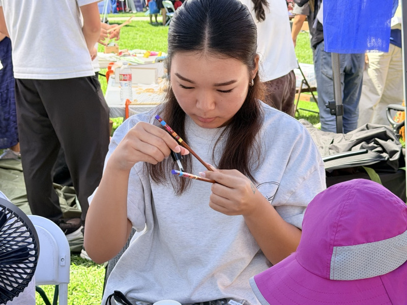 民眾在韓國文化攤位「筷子故事」(Chopstick Story)體驗手工製作木筷,從削製、打磨到上油,在動手過程中認識韓國筷子文化。(薛明珠/大紀元)