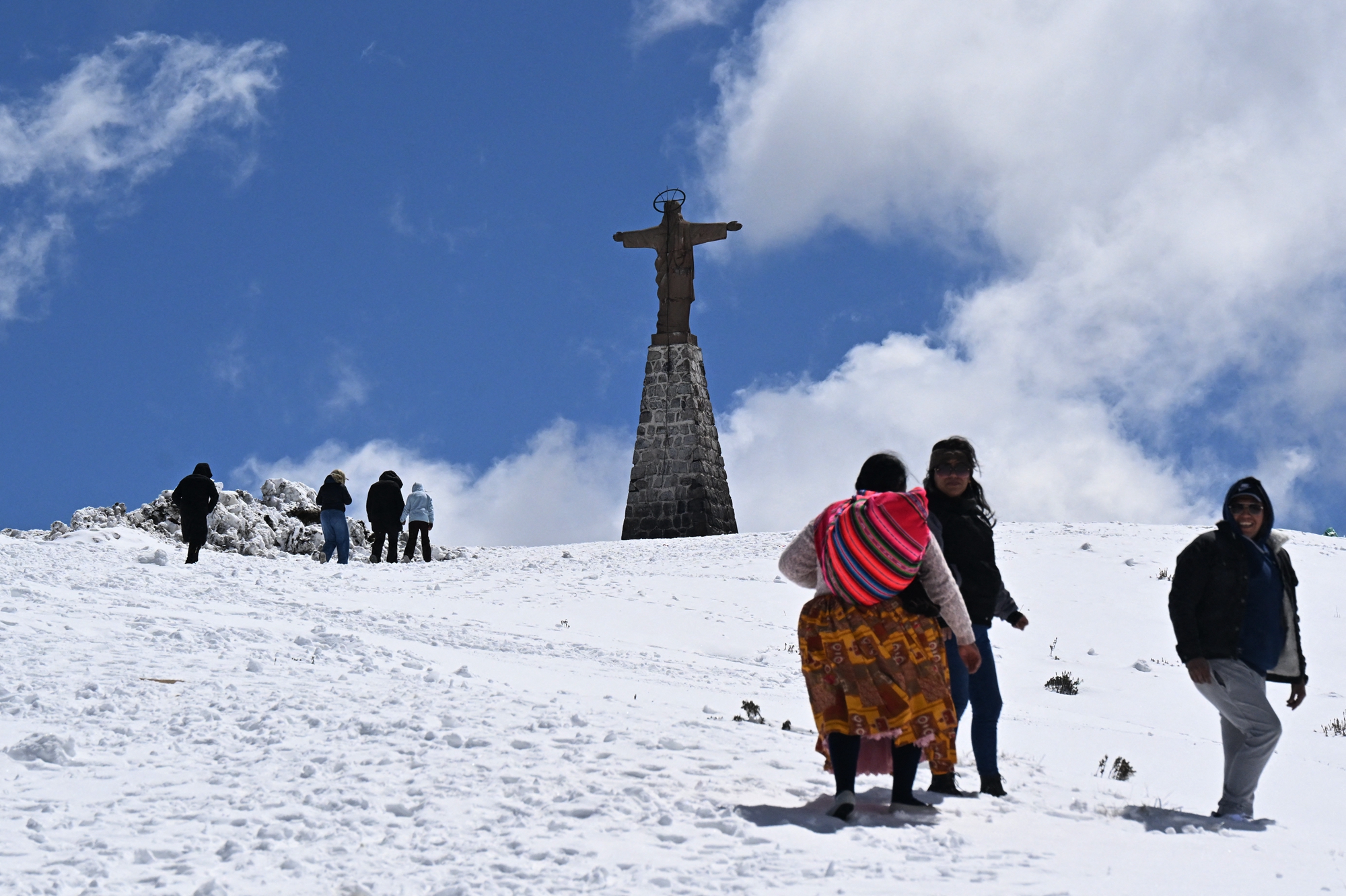2026年8月25日,玻利維亞拉巴斯省,拉巴斯北部峰區沿永加斯路(Yungas Road)一帶出現異常強降雪,當地民眾在雪中行走。(Aizar Raldes/AFP via Getty Images)