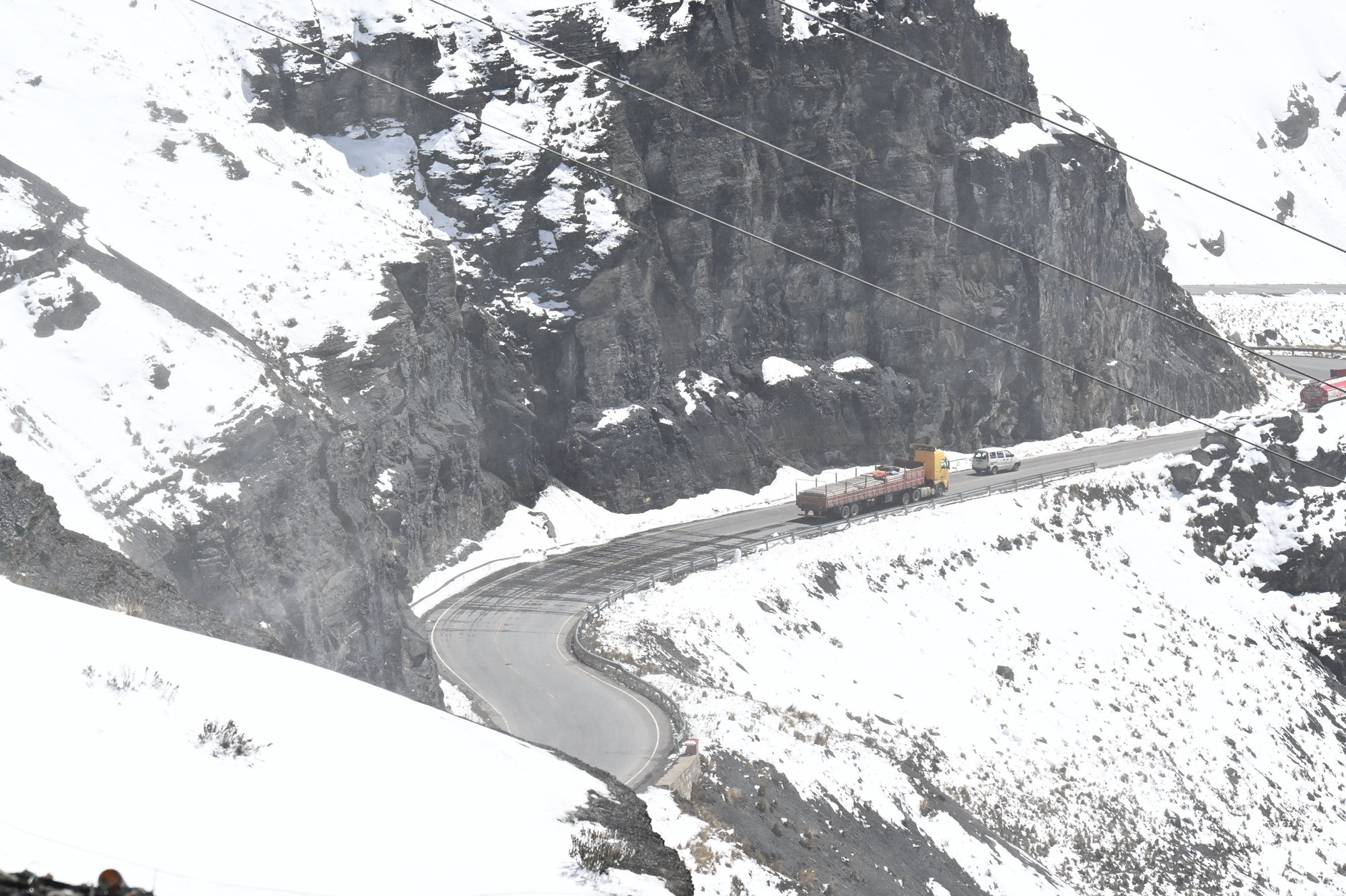 2026年8月25日,玻利維亞拉巴斯省,拉巴斯北部峰區沿永加斯路(Yungas Road)一帶出現異常強降雪,少數車輛沿著盤山路行駛。(Aizar Raldes/AFP via Getty Images)